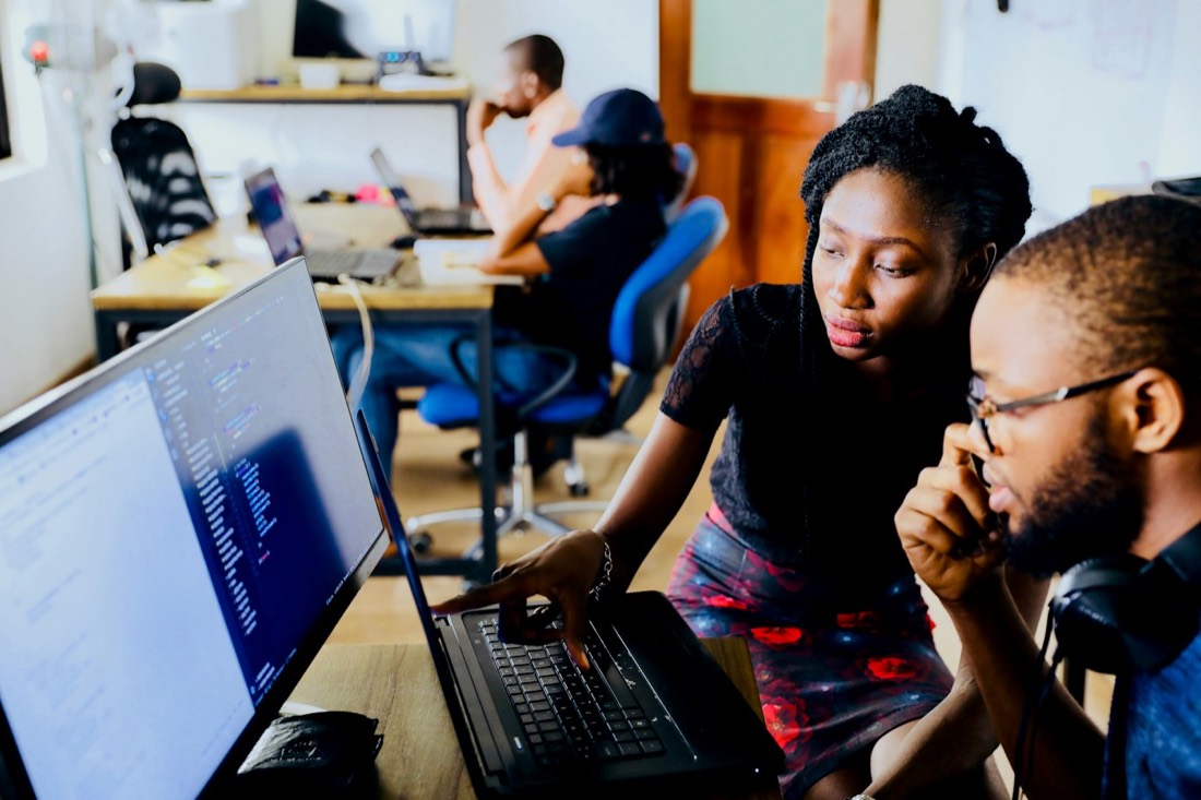 Two colleagues reviewing a process together on a laptop